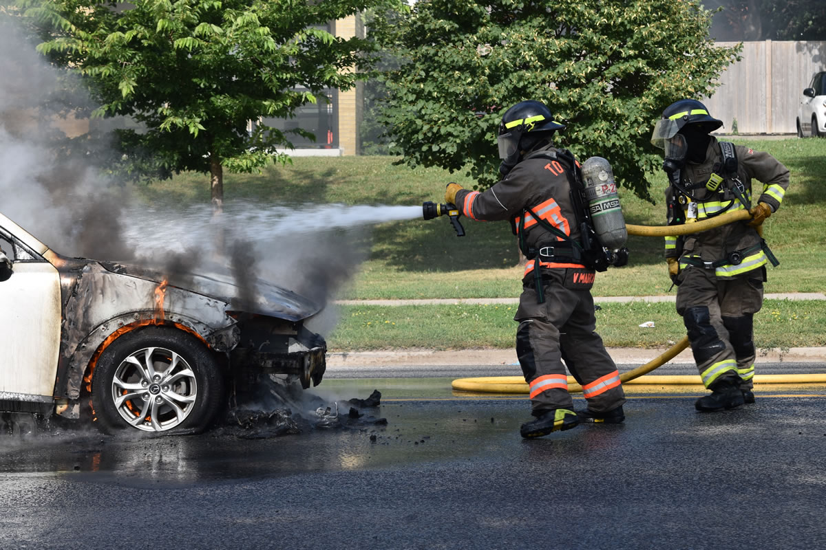 Firefighters fighting a car fire